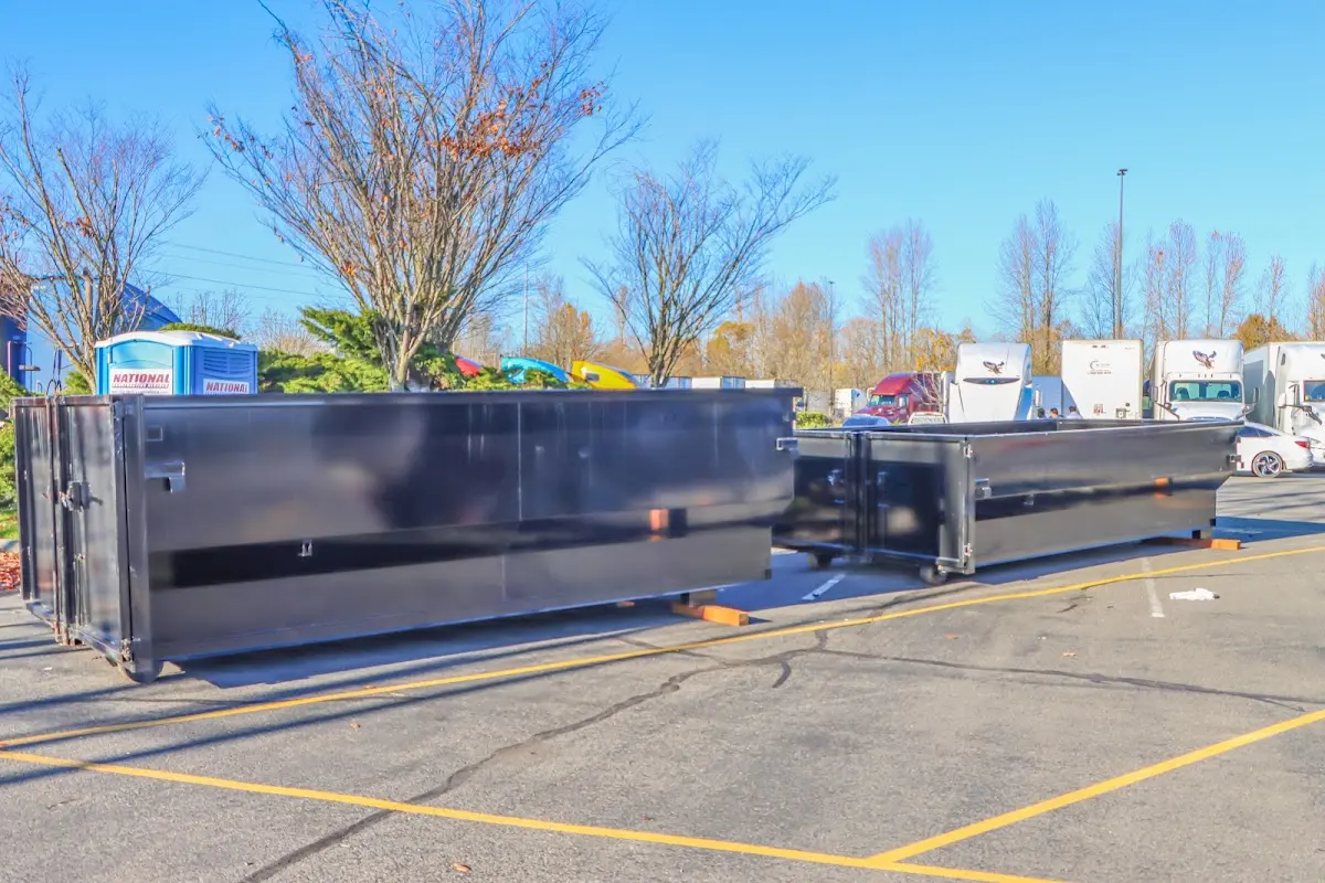 Professional dumpster rental service with roll-off container on residential driveway in Federal Heights